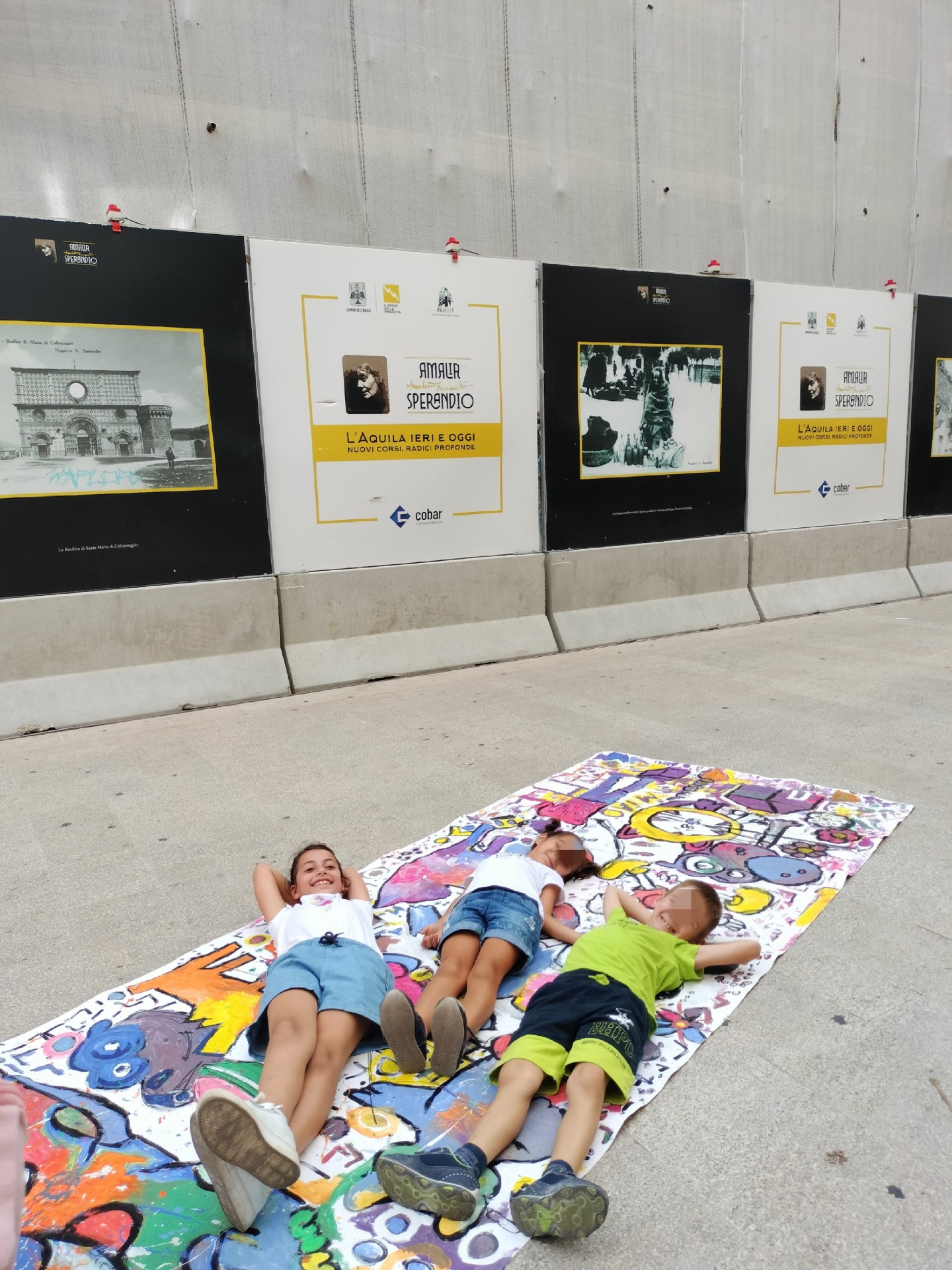 Due bambini si distendono su un'opera calpestabile dei Fratellini Margiotta.