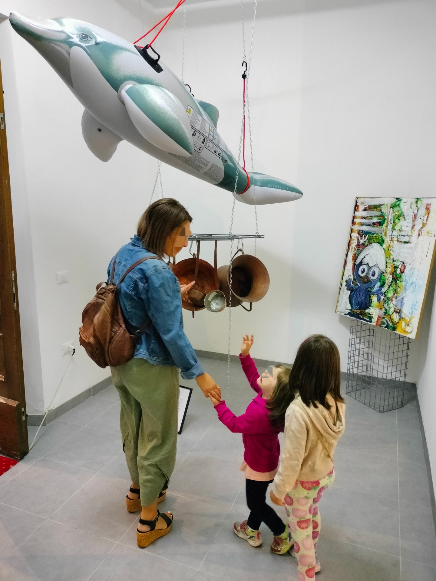 Una bambina accompagna la mamma verso un'opera dei Fratellini Margiotta e la indica.