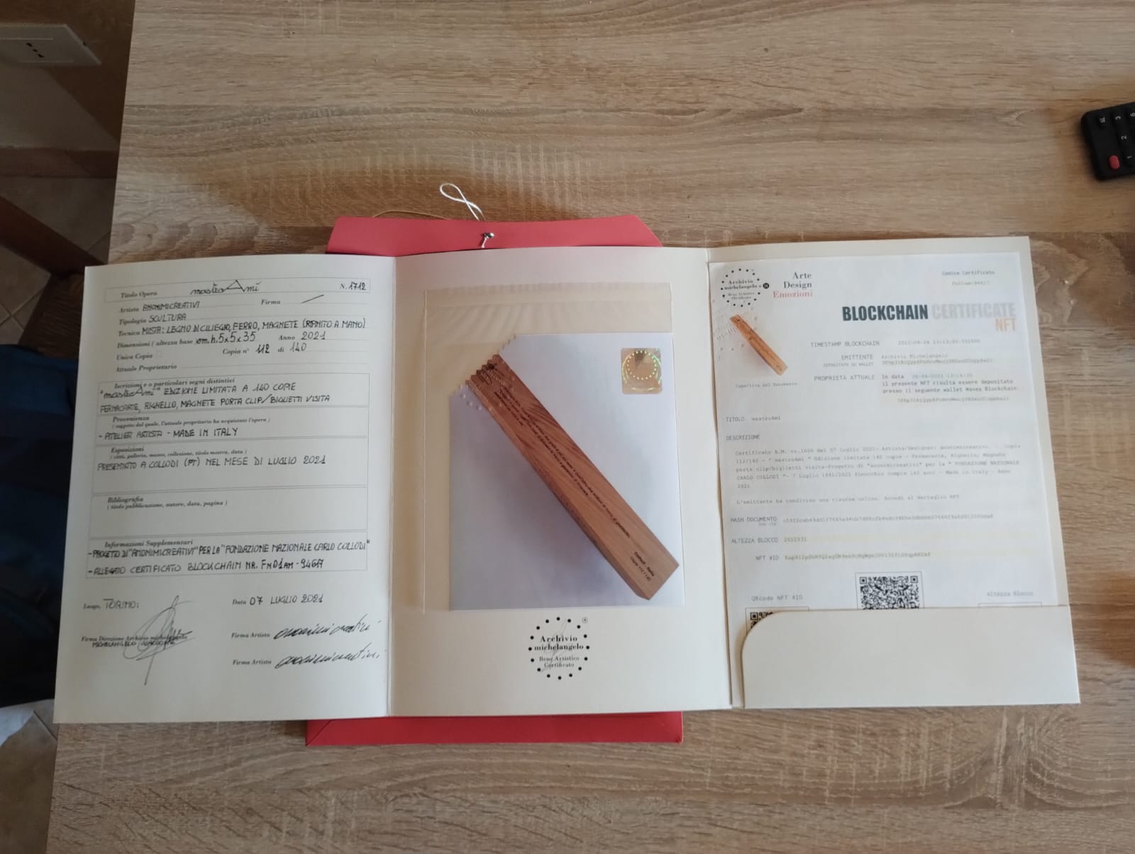 Tre documenti su tavolo: certificato blockchain Nft, foglio firmato e certificazione. Riconoscimento per i Fratellini Margiotta dalla Fondazione Collodi